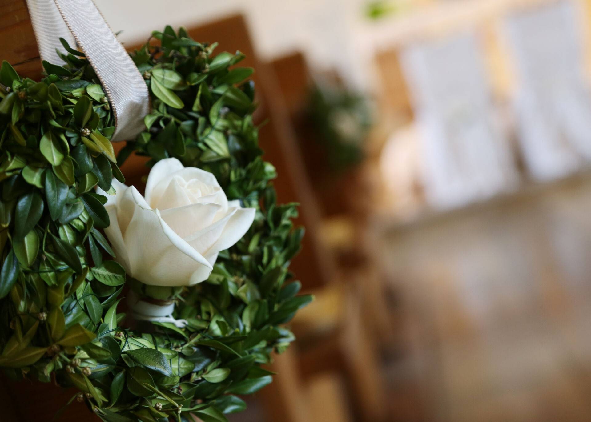 Holzbänke, an rechtem Ende Blumengesteck